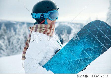 Ski Goggles Of Snowboarder With The Reflection Of Snowed Mountains. Winter Sports. Portrait Of Woman On The Background Of Mountains and Sunset. 133217323