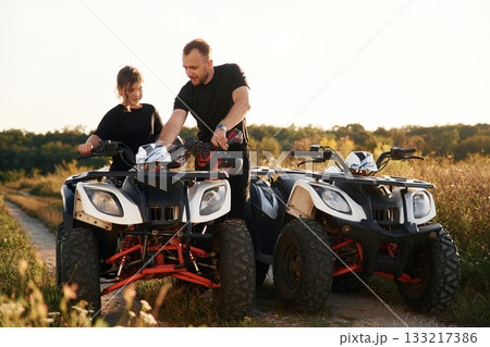 Showing how the machine works. Father and daughter are with ATV outdoors 133217386