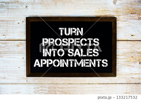 Turn Prospects Into Sales Appointments text with gift box present and alarm clock on black background 133217532
