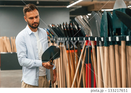 Selecting the new equipment. Man is in the hardware shop Selecting the new equipment. Man is in the hardware shop 133217651