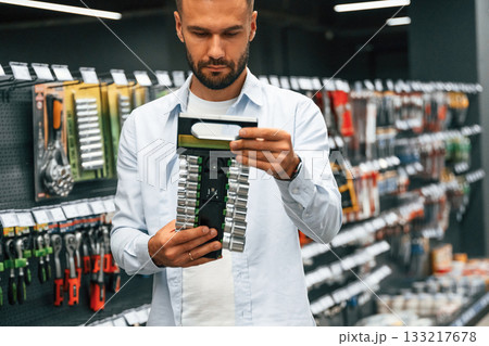 Selecting the new equipment. Man is in the hardware shop 133217678
