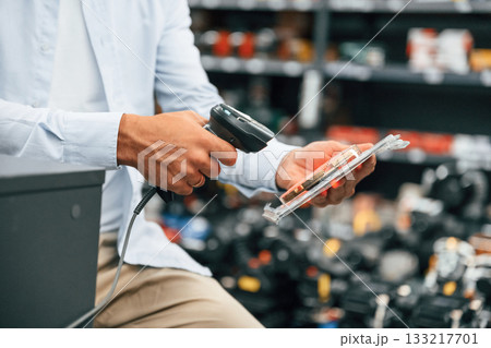 Cashier is at work. Man is in the hardware shop 133217701