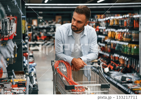Looking for the nice hardware. Man is in the hardware shop Looking for the nice hardware. Man is in the hardware shop 133217711