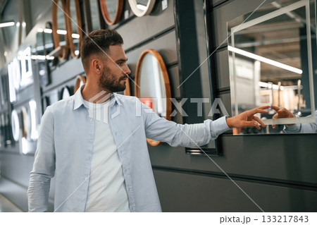 Smart mirror, touching it. Man is in the hardware shop 133217843