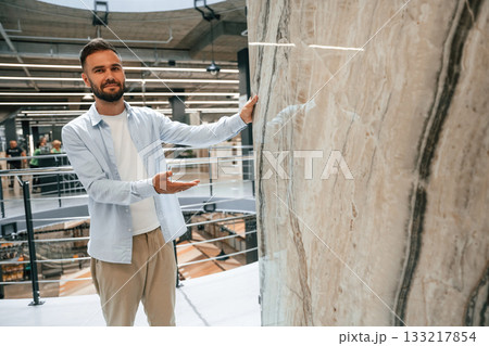 Huge tile, for floor or wall. Man is in the hardware shop Huge tile, for floor or wall. Man is in the hardware shop 133217854
