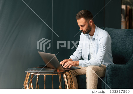 Businessman is sitting and working by using laptop Businessman is sitting and working by using laptop 133217899