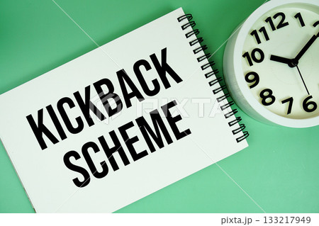kickback schemes text with alarm clock flat lay on green background kickback schemes text with alarm clock flat lay on green background 133217949