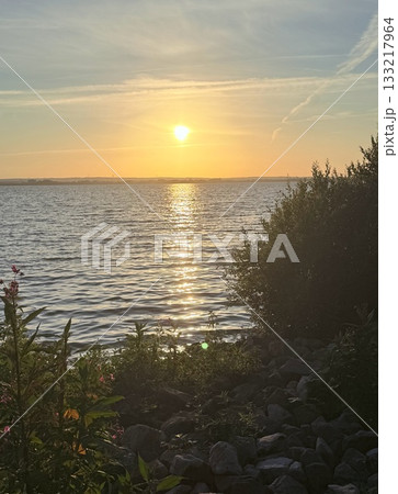 As the sun dips behind the horizon, casting a warm glow over the verdant landscape of rolling hills and meandering rivers, you find yourself nestled amidst the tranquil embrace of nature. 133217964