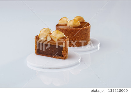Caramel tart with walnut against white background Caramel tart with walnut against white background 133218000