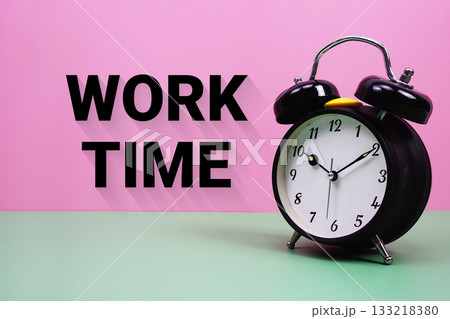 Black alarm clock on a pastel green and pink background with the text "Work Time" 133218380