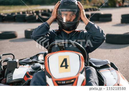 Front view, driving. Man is outdoors, kart racing conception 133218580
