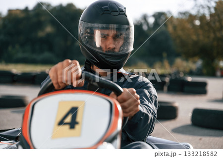 Front view, driving. Man is outdoors, kart racing conception Front view, driving. Man is outdoors, kart racing conception 133218582