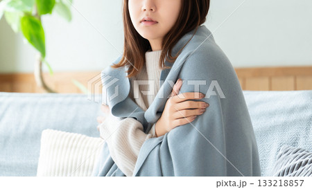 寒気がしてブランケットを羽織る女性 寒気がしてブランケットを羽織る女性 133218857