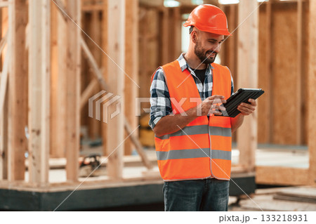 Manager is with digital tablet. Industrial worker in wooden warehouse 133218931