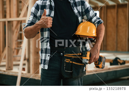 Job is going fine, showing thumb up. Industrial worker in wooden warehouse Job is going fine, showing thumb up. Industrial worker in wooden warehouse 133218978