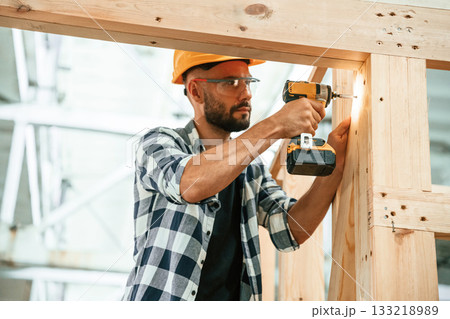 Busy, drilling the hole. Industrial worker in wooden warehouse Busy, drilling the hole. Industrial worker in wooden warehouse 133218989