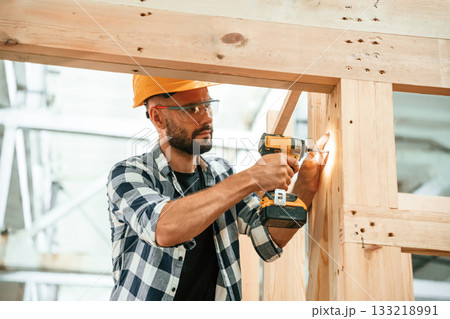 Busy, drilling the hole. Industrial worker in wooden warehouse Busy, drilling the hole. Industrial worker in wooden warehouse 133218991