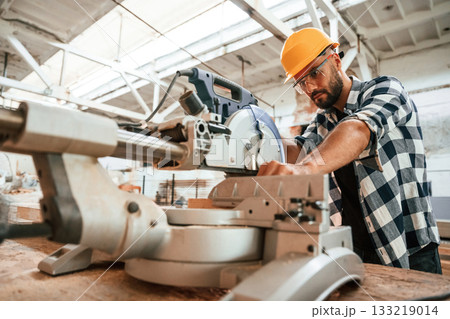 Focused, woodworking. Man is in warehouse Focused, woodworking. Man is in warehouse 133219014