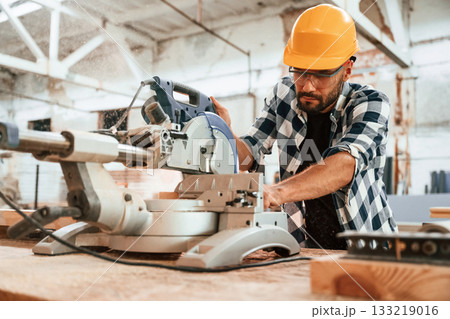Focused, woodworking. Man is in warehouse Focused, woodworking. Man is in warehouse 133219016