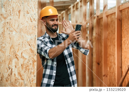 Using the smartphone. Industrial worker in wooden warehouse 133219020