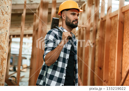 Hammer in hand. Industrial worker in wooden warehouse 133219022