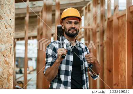 Hammer in hand. Industrial worker in wooden warehouse 133219023