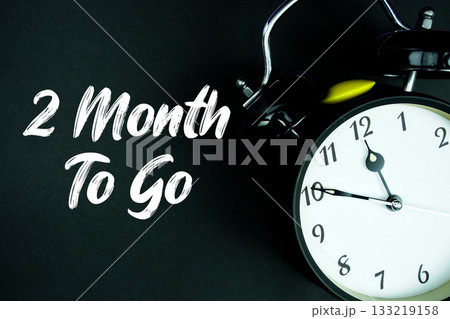 2 Month To Go text and alarm clock on black background 133219158