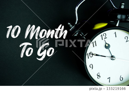 10 Month To Go text and alarm clock on black background 10 Month To Go text and alarm clock on black background 133219166