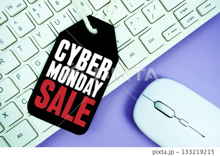 Price tag with text "Cyber Monday Sale" and white keyboard and wireless mouse on purple background 133219215