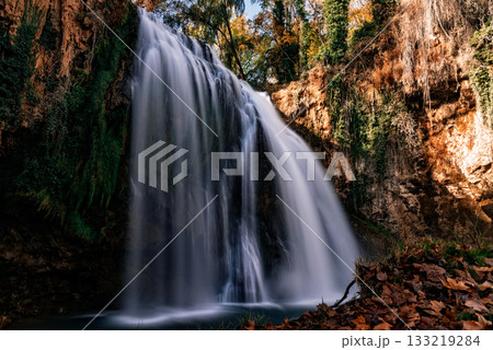 Long exposure waterfall cascading over mossy cliffs in autumn forest Long exposure waterfall cascading over mossy cliffs in autumn forest 133219284