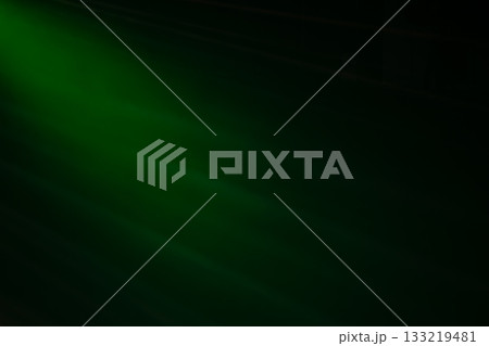 A green background with a light shining on it. The light is coming from the left side. The background is dark and the light is bright 133219481