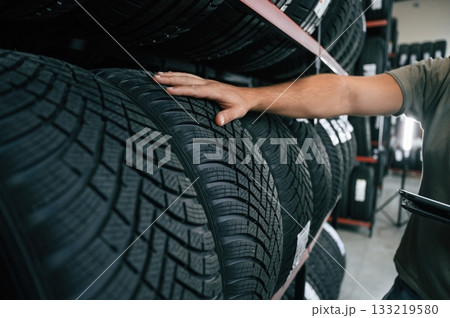 Quality control, manager is looking for stuff. Man is in the tire fitting car service 133219580
