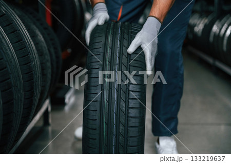Detailed close up view, moving the wheel. Man is in the tire fitting car service 133219637
