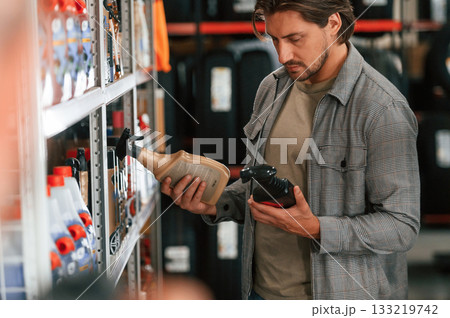 Customer is choosing oil for the car in the shop Customer is choosing oil for the car in the shop 133219742