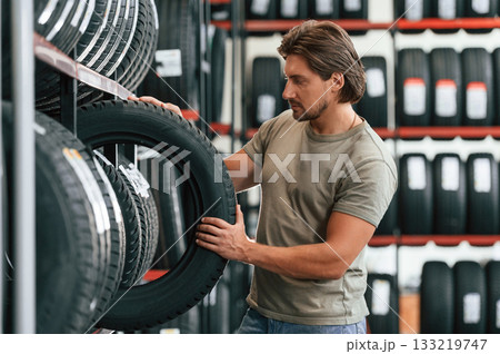 Customer is choosing the tire. Man is in the tire fitting car service Customer is choosing the tire. Man is in the tire fitting car service 133219747
