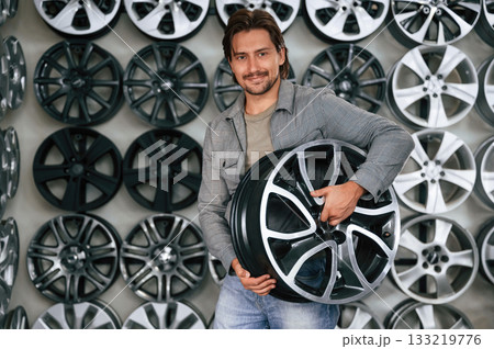 Big choice. Man is in the tire fitting car service 133219776