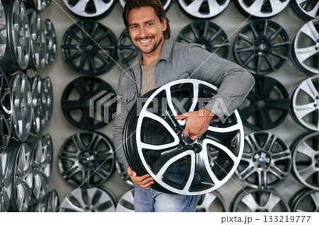 Big choice. Man is in the tire fitting car service Big choice. Man is in the tire fitting car service 133219777