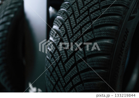 Particle close up view. New tires are placed on the storage rack in the car workshop 133219844
