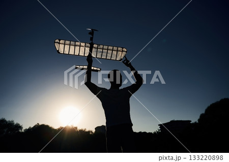 Man is holding wooden toy plane in hands, dark, dawn Man is holding wooden toy plane in hands, dark, dawn 133220898
