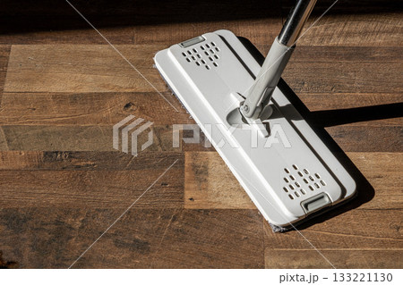 Top view of a flat microfiber mop on a wooden floor in natural light Top view of a flat microfiber mop on a wooden floor in natural light 133221130