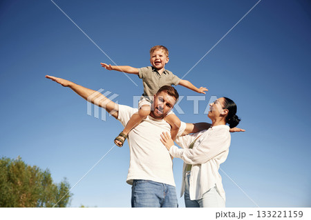 Hands to the sides, flying, imagination. Mother and father are with son outdoors on the field Hands to the sides, flying, imagination. Mother and father are with son outdoors on the field 133221159