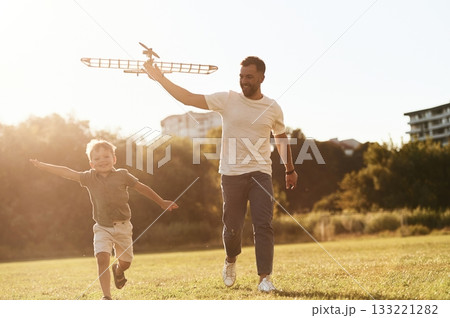 Running, fun. Father and son are on the field together with toy plane Running, fun. Father and son are on the field together with toy plane 133221282