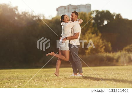 Embracing each other. Lovely couple are having a walk on the field Embracing each other. Lovely couple are having a walk on the field 133221403