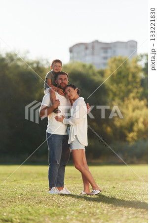 Three people. Mother and father are with son outdoors on the field 133221830