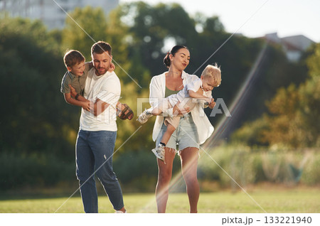 Husband and wife. Parents with two little sons are on the field together Husband and wife. Parents with two little sons are on the field together 133221940