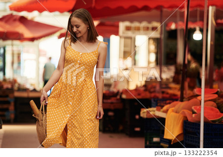 With baguette. Young woman is on the vegetable market or bazaar With baguette. Young woman is on the vegetable market or bazaar 133222354