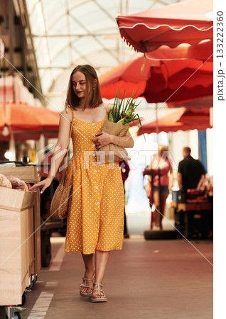 Cheerful, feeling happy. Young woman is on the vegetable market or bazaar Cheerful, feeling happy. Young woman is on the vegetable market or bazaar 133222360