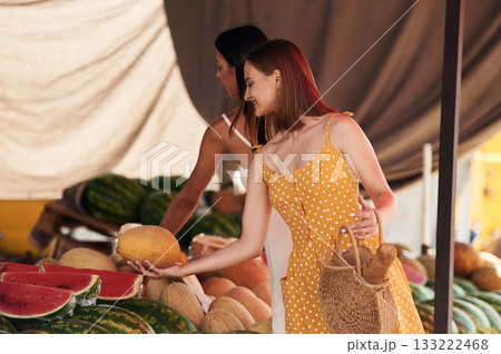 Friend is holding the melon. Two women are together on the marker or bazaar Friend is holding the melon. Two women are together on the marker or bazaar 133222468