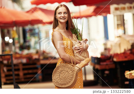 With spring onion. Young woman is on the vegetable market or bazaar 133222580