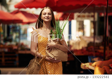 Spring onion, front view. Young woman is on the vegetable market or bazaar 133222581